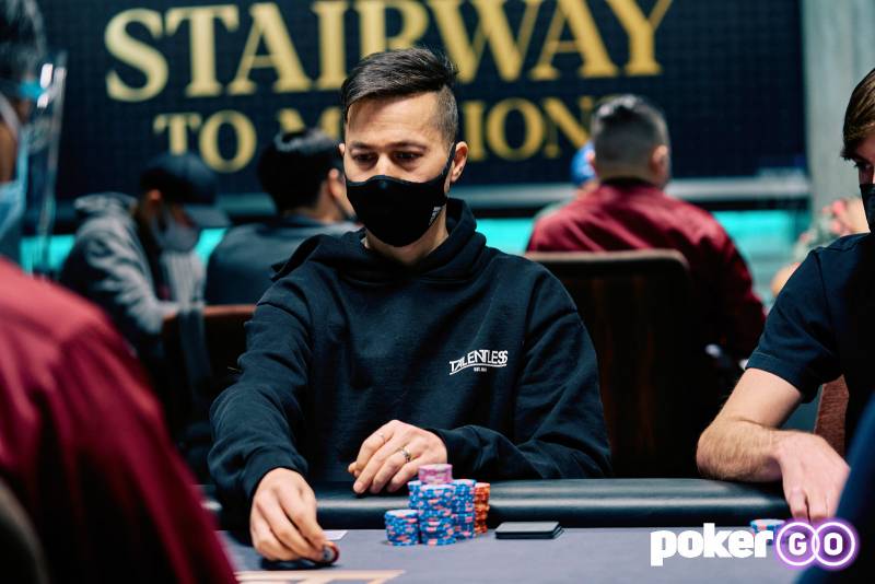 Daniel Weinand w maseczce, siedzi przy stole eventu #3 Stairway to Millions